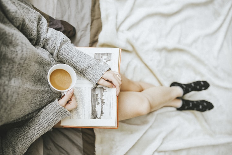 Girl reading a book with a coffee